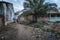 Two boys walking in a dirt street along an open sewer at the Cupelon de Baixo neighborhood in the city of Bissau