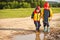 Two boys walking through a mud puddle