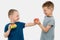 Two boys on a white background, one with a hamburger, the second offers him fruit.Concept-the older brother insistently suggests