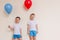 Two boys in white shirts with balloons