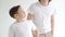 two boys in white T-shirts pose for a photographer in a photo studio.