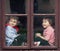 Two boys on the window, laughing and drinking tea