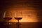 The two brandy glasses on a wooden background. Cognac on the table