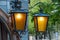 Two brass lanterns on a green background