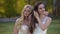 Two brides are posing in the sunshine against a beautiful landscape of autumn nature. Brunette and blonde women