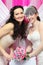 Two brides wearing white dresses hold bouquet