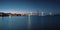 Two bridges against the sunset sky and city embankment in lights