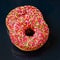 Two bright glazed donuts on dark minimal background, top view