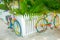 Two brightly painted bicycles leaning on picket fence on residential street corner