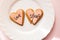 Two broken heart gingerbread cookies decorated with pink fondant with the message love stinks. heartbreak concept