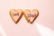 Two broken heart gingerbread cookies decorated with pink fondant with the message love stinks. heartbreak concept