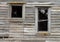 Two Broken Windows in a Dilapidated Wooden House