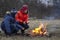 Two brother roasting hotdogs on sticks at bonfire. Children having fun at autumn camp fire. Camping kids in fall forest