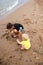 Two brothers children playing on the sand beach by the sea