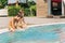 Two brothers Childs laughing while playing in swimming pool at sunny day. Kids friends boys refreshing at heat weather