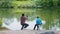 Two brothers on fishing - man pulling the rod and his little brother watching him