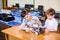 Two brothers kids playing with robot toy at school robotics class, indoor.