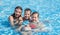 Two brothers and older sister swim in the outdoor children`s pool happy