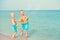 Two brothers play on the beach with water pistols. Summer time.