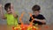 Two brothers play a Board game on a wooden table