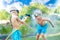 Two brothers play on a summer hot day in the garden. Children are splashing with a garden hose.