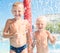 Two brothers rest in the aqua park, stand under the spray of water.Summer time.