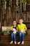 two brothers sitting on wooden, having fun playing with rabbits