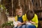 Two brothers sitting on wooden, having fun playing with rabbits