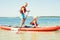 Two brothers swimming on stand up paddle board.Water sports , active lifestyle.