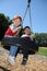 Two brothers on a tire swing