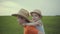 Two brothers are walking in the field in straw hats in the summer.