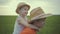 Two brothers are walking in the field in straw hats in the summer.