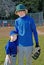 Two brothers wearing baseball uniforms.