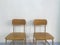 Two brown empty school chairs with white wall