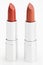 Two brown lipsticks isolated over white