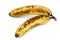 Two brown spotted, overripe bananas on white background