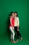 Two brunette girlfriends posing on green background