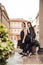 Two brunette girls dressed in black strolling through the city of Milan, Italy