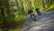 Two brutal men motorcyclists in helmet riding a motorbike in the forest - a camera following the moves of bikers