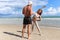 Two buddy doing body stretching exercises outdoor on summer tropical island beach with blue sea, couple doing exercise outdoor,