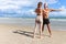 Two buddy doing body stretching exercises outdoor on summer tropical island beach with blue sea, couple doing exercise outdoor,