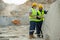 Two builders in hardhats and workwear discussing working points