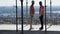 Two builders look at the river landscape from the building under construction