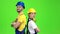 Two builders stand back to back and point with their fingers straight. Green screen. Slow motion