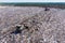 Two bulldozer working on mountain of garbage in landfill