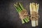 Two bundles of fresh asparagus tied with hessian