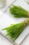 Two bundles of fresh barley grass on a white table