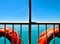 Two buoys white metal railings sea and sky