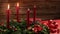 Two burning red candles on a traditional advent wreath with festive decoration
