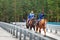 Two Buryat boys ride horses on bridge in Arshan. Russia